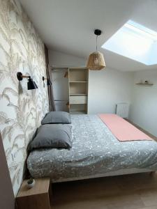 1 dormitorio con 1 cama grande y tragaluz en Gîte Ambroise (proche Puy du fou), en La Petite-Boissière