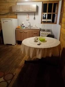 una cocina con una mesa con un tazón verde. en Cabaña en el bosque de punta del diablo, en Punta del Diablo