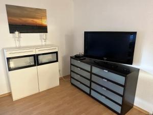a living room with a flat screen tv on a dresser at Mühlenparadies Hameln in Hessisch Oldendorf