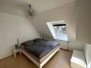 um quarto com uma cama, uma janela e um lustre em Mühlenparadies Hameln em Hessisch Oldendorf