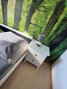 um quarto com uma cama e uma janela com um mural de árvore em Mühlenparadies Hameln em Hessisch Oldendorf