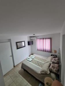 een witte slaapkamer met een bed en een raam bij DOS ANGELES in Salta