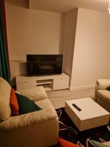 a living room with a couch and a tv at Family Home in Liverpool