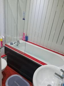 a bathroom with a sink and a tub and a toilet at Family Home in Liverpool