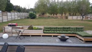 a green couch sitting on top of a patio at Rock and chill house with jacuzzi Namur Ardennes in Namur