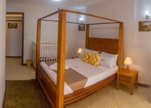 ein Schlafzimmer mit einem Holzbett mit einem Holzrahmen in der Unterkunft The Zanakri homes Oceanfront in Mombasa + 86 Fotos