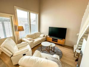 a living room with white furniture and a flat screen tv at Vuokatin kultaranta in Sotkamo