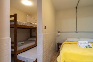 two bunk beds in a small room with yellow sheets at Hostel B2B SP in Sao Paulo