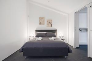 een slaapkamer met een bed met twee handdoeken erop bij Archimedes luxury apartment with terrace in Palermo