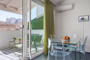 comedor con mesa de cristal y sillas en Archimedes luxury apartment with terrace, en Palermo