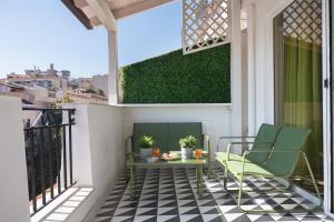 een patio met 2 stoelen en een tafel op een balkon bij Archimedes luxury apartment with terrace in Palermo