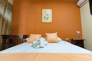 1 dormitorio con 1 cama con paredes de color naranja en El Cocobolo Food&Rest Room 5 Bed and Breakfast WiFi AC Pkg gratis, en Liberia