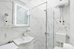 a white bathroom with a sink and a shower at Apartments Rozer in Kotor +37 photos