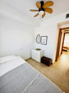 a bedroom with a bed and a ceiling fan at Apartamento con Piscina y Jardín Espectacular Cala Sirenas - Nuevo in Miami Platja