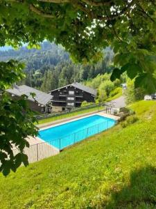 a swimming pool in the middle of a grassy hill at Le Cristal du Mont-Blanc in Saint-Gervais-les-Bains