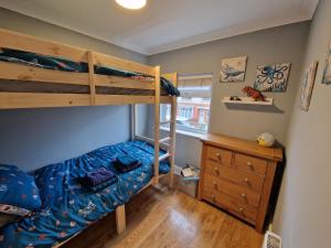 a bedroom with two bunk beds and a wooden dresser at Wishbone House in Bridlington