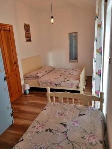 1 dormitorio con 2 camas individuales y alfombra en Vintage stone house ELDO in Podaspilje, Omiš, en Omiš