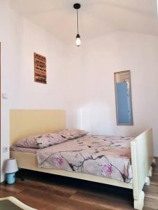 Schlafzimmer mit einem Bett und einem Wandspiegel in der Unterkunft Vintage stone house ELDO in Podaspilje, Omiš in Omiš