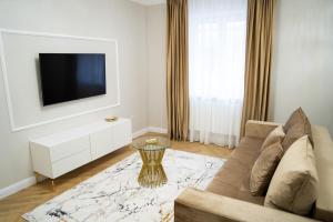 a living room with a couch and a tv at Central Parc Apartment 1 ! Self Check-in ! Free Parking ! WiFi in Suceava