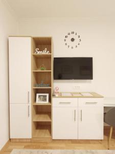 Il comprend un salon doté d'un bureau blanc et d'une télévision. dans l'établissement Apartment SUNSET II, à Trebinje