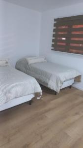 dwa łóżka siedzące obok siebie w pokoju w obiekcie USHUAIA FOR´NS w mieście Ushuaia