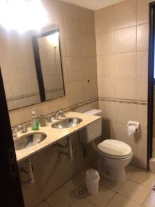 a bathroom with two sinks and a toilet and a mirror at Departamento zona residencial CON PILETA in Salta