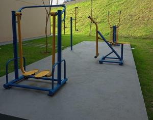 zwei leere Fitnessgeräte in einem Park in der Unterkunft Condomínio da fé Canção Nova Com Garagem in Cachoeira Paulista