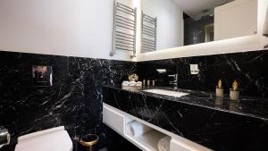a black bathroom with a toilet and a sink at Cihangir Residences in Istanbul