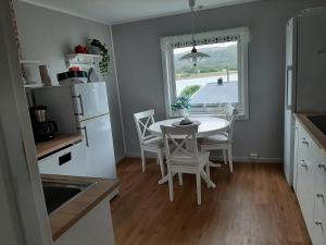 a kitchen with a table and chairs and a window at Holiday Apartment in Flatanger in Vik