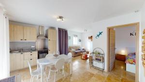 een keuken en een woonkamer met een witte tafel en stoelen bij Lou Colibri in Le Thoronet