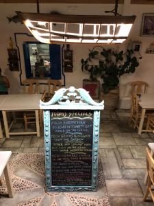 a restaurant with a sign in the middle of a room at TO VOTSALO-beach side studios & taverna in Karpathos Town