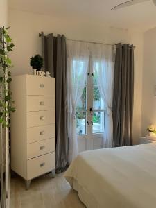 a bedroom with a bed and a dresser and a window at Home Away From Home Marbella in Marbella