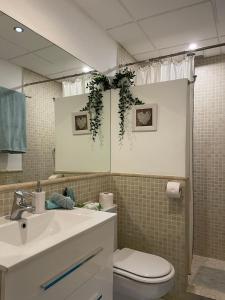 La salle de bains est pourvue d'un lavabo, de toilettes et d'un miroir. dans l'établissement Home Away From Home Marbella, à Marbella
