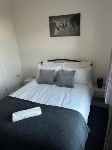 a bedroom with a bed with white sheets and pillows at Stylish Town House - Modern double room - 4 in Parkside