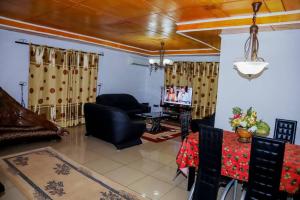 a living room with a couch and a tv at Ocean Breeze in Limbe