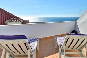 two chairs on a balcony with the ocean in the background at Village Center - Ocean View in Ericeira