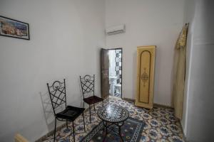 um quarto com cadeiras, uma mesa e um espelho em Dar Fez Unique em Fez