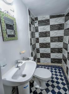 uma casa de banho com um lavatório branco e um WC. em Dar Fez Unique em Fez