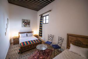 um quarto com uma cama, um sofá e uma mesa em Dar Fez Unique em Fez