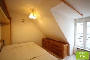 a attic bedroom with a bed and a window at Studio classé 4 personnes face aux Thermes, avec coin nuit in Le Mont-Dore