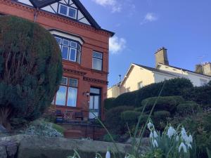 a red brick house with white flowers in front of it at The Views Bed and Breakfast in Llangollen