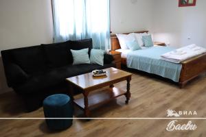 sala de estar con sofá y cama en ВИЛА БАЕВИ, en Velingrad