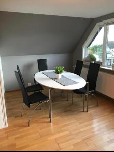 une salle à manger avec une table et des chaises blanches dans l'établissement Lägenhet med balkong, à Mölle