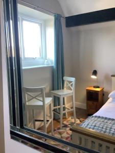 1 dormitorio con 2 sillas, 1 cama y 1 ventana en The Views Bed and Breakfast, en Llangollen