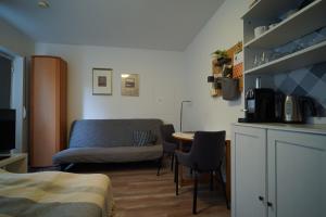 een woonkamer met een bank en een tafel bij Kleines Souterrain Apartment direkt am Park in Wiesbaden