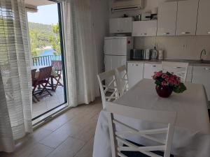 a kitchen with a table and chairs and a balcony at Apartment Nono Ivo in Vis