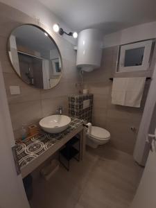 a bathroom with a sink and a toilet and a mirror at Apartment Nono Ivo in Vis