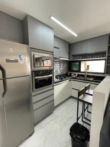 a kitchen with stainless steel appliances and a table at Flats do Lucca in Tamandaré