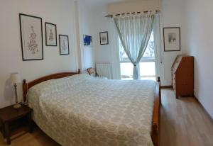 Un dormitorio con una cama grande y una ventana en La Casa di Flavio Casa Vacanze, en Albenga