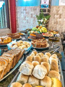 un buffet lleno de diferentes tipos de pan y repostería en Pousada Boa Sorte en Cumuruxatiba